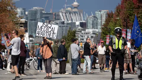 08 September 2021, Canada, Vancouver: A police officer directing traffic around the road closure stands by as people attend a rally organized by those opposed to COVID-19 vaccination passports and public health measures. Photo: Darryl Dyck/The Canadian Press via ZUMA/dpa