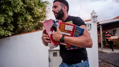 20 September 2021, Spain, La Palma: A man carries books from a house during the evacuation due to the volcano eruption. For the first time in 50 years, a volcano has erupted again on the Spanish Canary Island of La Palma. Photo: Arturo Jiménez/dpa