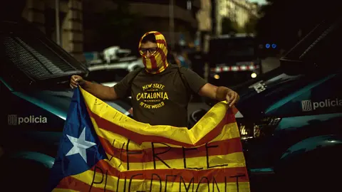 24 September 2021, Spain, Barcelona: A protester holds a Catalan pro-independence flag during a protest near the Italian Consulate General in Barcelona against the arrest of Catalan ex-government leader Carles Puigdemont. The former Catalan head of government Puigdemont has been arrested on the Italian Mediterranean island of Sardinia. Photo: Matthias Oesterle/ZUMA Press Wire/dpa