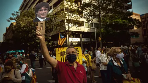 24 September 2021, Spain, Barcelona: A protester holds a picture of Carles Puigdemont during a protest near the Italian Consulate General in Barcelona against the arrest of Catalan ex-government leader. The former Catalan head of government Puigdemont has been arrested on the Italian Mediterranean island of Sardinia. Photo: Matthias Oesterle/ZUMA Press Wire/dpa