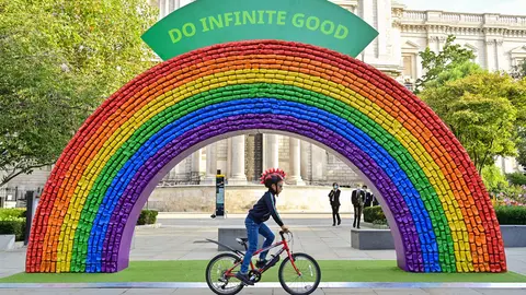 Hugo, aged 7, rides past a 4x7 metre rainbow arch in front of St Paul's Cathedral in London, made entirely of recycled aluminium cans, which has been installed by recycling initiative "Every Can Counts", in partnership with The City of London Corporation, to encourage people to recycle. Photo: Matt Crossick/PA Wire/dpa