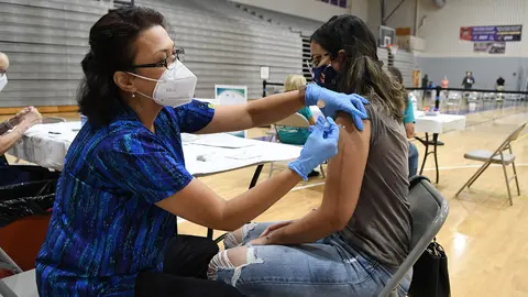 11 September 2021, US, Winter Springs: Nurse Susanna Bryan (L) administers a dose of the Pfizer COVID-19 vaccine to Joann Cortes at a vaccination clinic at Winter Springs High School. As of 10 September 2021, 54% of Florida's population has been fully vaccinated. Photo: Paul Hennessy/SOPA Images via ZUMA Press Wire/dpa