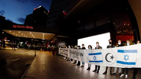 05 October 2021, Saxony, Leipzig: Employees of the Westin Hotel who want to set a sign against anti-Semitism with a banner. Following allegations of anti-Semitism, hundreds of people gathered in front of the "Westin Hotel" Leipzig this evening to show solidarity with the musician Gil Ofarim and Jews in Germany. Ofarim had been the victim of an anti-Semitic incident at the Leipzig hotel on Monday, according to his own account. An employee of the "Westin Leipzig" had asked him at the reception to pack his Star of David. Photo: Dirk Knofe/dpa.