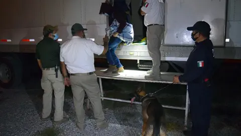 HANDOUT - 08 October 2021, Mexico, Hidalgo: Police and officials help migrants out of a truck. Soldiers in Mexico discovered a total of 652 Central American migrants hiding in three sealed refrigerated cargo trucks, the country's INM immigration agency said on Friday. Photo: --/Regierung des Bundesstaates Tamaulipas/dpa - ACHTUNG: Nur zur redaktionellen Verwendung im Zusammenhang mit der aktuellen Berichterstattung und nur mit vollständiger Nennung des vorstehenden Credits
