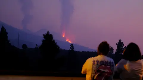 17 October 2021, Spain, La Palma: Two people look at one of the eruptive mouths of the Cumbre Vieja volcano on the Canary Island of La Palma. Photo: -/EUROPA PRESS/dpa