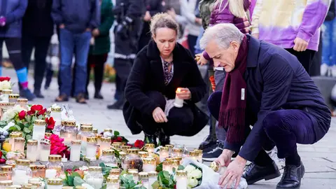 15 October 2021, Norway, Kongsberg: Norwegian Prime Minister Jonas Gahr Store (R) lays flowers and lights candles for the victims of a violent armed attack that left five people killed and two injured on Wednesday night. Photo: Terje Bendiksby/NTB/dpa