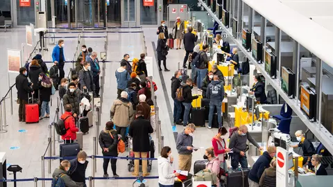 29 October 2021, Bavaria, Munich: Passengers stand at a check-in counter at Munich Airport. In Bavaria, the autumn holidays start on 29 October 2021. Photo: Sven Hoppe/dpa