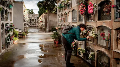 01 November 2021, Spain, Barcelona: A woman places a flower on the grave where her relatives rest at the Poblenou cemetery on All Saints Day, a Catholic holiday dedicated to the memory of the deceased. Photo: Jordi Boixareu/ZUMA Press Wire/dpa.