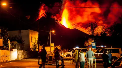 28 October 2021, Spain, La Palma: A group of people watch the lava flow and pyroclasts coming out of the Cumbre Vieja volcano in La Palma in the Canary Islands. The lava now covers a total of 911.6 hectares and has destroyed 2,183 buildings. Photo: -/EUROPA PRESS/dpa