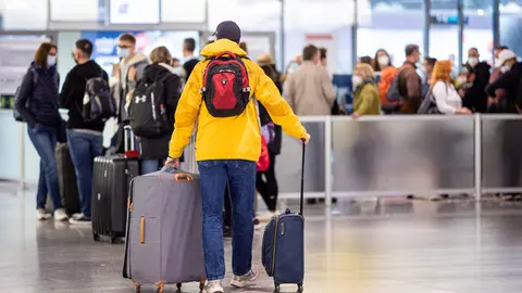 16 October 2021, Lower Saxony, Langenhagen: Numerous passengers wait at Hannover Airport. Because the service provider commissioned by the Federal Police to carry out the handling checks has massive staffing problems, there have recently been long waiting times, with some passengers missing their flights as a result. Photo: Moritz Frankenberg/dpa.