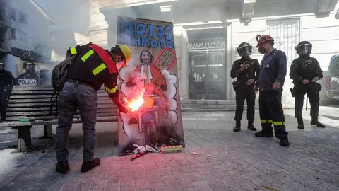 10 October 2021, Spain, Lugo: A demonstrator sets fire to a banner with a portrait of the Spanish Minister of Industry, Reyes Maroto, during a joint rally of workers of Alcoa and Vestas factories to against job cuts and to demand the prevention of the factories' shutdown. Photo: Carlos Castro/EUROPA PRESS/dpa