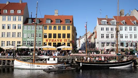 FILED - Passers-by walk along Nyhavn, in Copenhagen, the harbour with its colourful little houses popular with tourists. Denmark lifted Corona measures in force in the country on September 10 but plans to reintroduce some measures in November after cases climbed. Photo: Steffen Trumpf/dpa.
