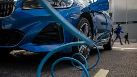 FILED - An electric car charges up at a BMW site in Leipzig, Germany. BMW chairperson Oliver Zipse on Wednesday warned that setting a date for the end of petrol and diesel cars could in fact harm the climate. Photo: Hendrik Schmidt/dpa-Zentralbild/ZB