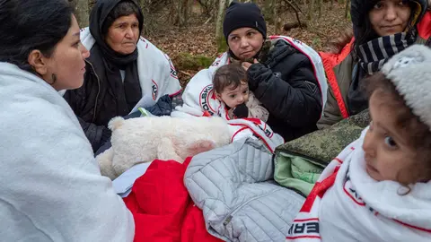 09 November 2021, Poland, Narewka: A refugee family warms themselves under blankets provided by Grupa Granica organization, as they sit in a forest near the Belarusian-Polish border. The Iraqi refugee family of seventeen, including nine children, called out to activists for help after spending seventeen days in a forest and got pushed back eight times. Photo: Jana Cavojska/SOPA Images via ZUMA Press Wire/dpa.