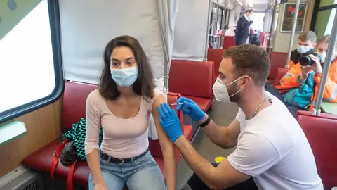 04 November 2021, Hessen, Frankfurt_Main: A woman gets her first vaccine jab inside the Vaccination Tram in Frankfurt. People who want to be vaccinated can board the tram, which runs on regular routes through Frankfurt, at any time without an appointment. Photo: Boris Roessler/dpa.