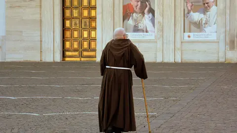 A friar walks towards the church leaning on a cane. Photo: Pixabay.