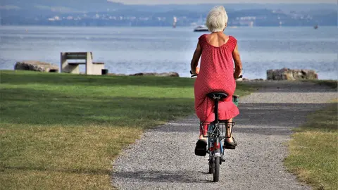An older lady rides a bicycle. Photo: Pixabay.