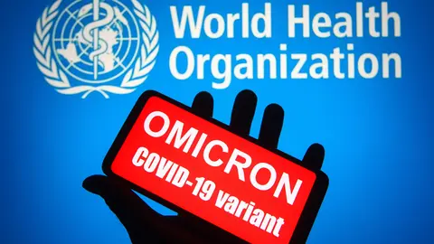 26 November 2021, Ukraine, ---: An illustration photo shows words that say "Omicron COVID-19 variant" displayed on a mobile phone screen in front of the World Health Organization (WHO) logo in the background. The mutated strain, called "Omicron" and described by the World Health Organization as "a strain of concern", reached Belgium after it was discovered in South Africa. Pharmaceutical companies are working to modify vaccines to counter the new mutated strain of the Coronavirus, which has sparked travel bans in many countries of the world. Photo: Pavlo Gonchar/SOPA Images via ZUMA Press Wire/dpa.