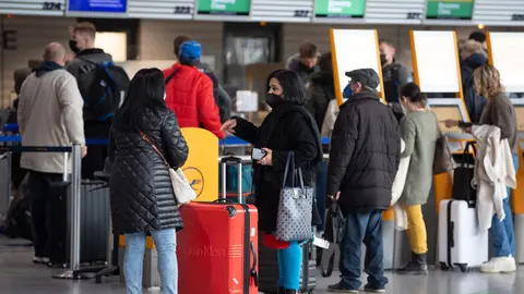Passengers wait in front of the check-in counters at Frankfurt Airport. German authorities announced restrictions on flights to South Africa on Friday, amid fears of a new virus variant there, even as they work to shore up its health care network amid a pandemic virus wave already infecting tens of thousands new people every day. Photo: Boris Roessler/dpa.
