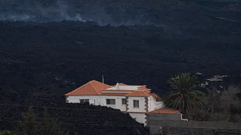 24 November 2021, Spain, Los Llanos: A house is half covered by volcanic lava from the Cumbre Vieja volcano. Since the volcano erupted on September 19, the lava has destroyed more than 2650 buildings, according to the latest tally from the European earth observation system Copernicus. Photo: Pau De La Calle/EUROPA PRESS/dpa.