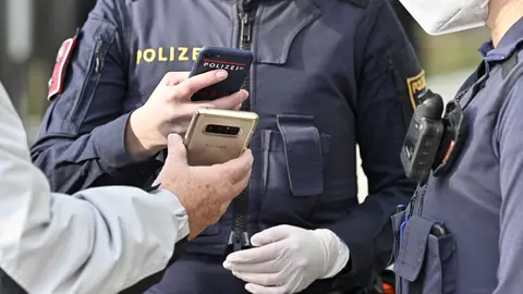 16 November 2021, Austria, Voesendorf: A policeman checks the covid passport of a citizen amid lockdown imposed by the authorities on unvaccinated people. Photo: Hans Punz/APA/dpa.