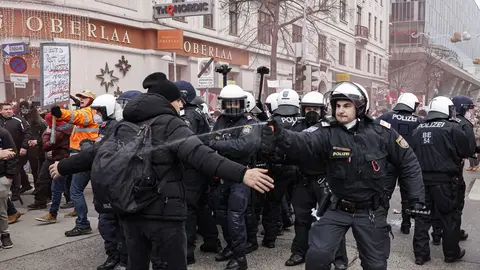 04 December 2021, Austria, Vienna: People clash with policemen during a protest against the compulsory vaccination and measures imposed to curb the spreading of coronavirus. Photo: Florian Wieser/APA/dpa.