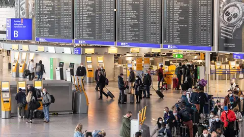 26 November 2021, Hessen, Frankfurt_Main: Passengers wait at Frankfurt Airport. German authorities announced restrictions on flights to South Africa on Friday, amid fears of a new virus variant there, even as they work to shore up its health care network amid a pandemic virus wave already infecting tens of thousands new people every day. Photo: Boris Roessler/dpa.