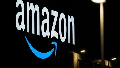 FILED - 17 December 2020, Brandenburg, Schoenefeld/Ot Kiekebusch: The Amazon logo is seen on the facade of a sorting centre. The Italian Competition Authority (AGCM) on Thursday fined Amazon more than a billion euros for abusing its dominant market position in Italy and breaking EU law. Photo: Soeren Stache/dpa-Zentralbild/dpa.