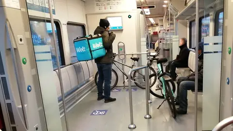 Wolt deliverymen, with their bicycles inside a train in Helsinki. Photo: The Nomad Today.