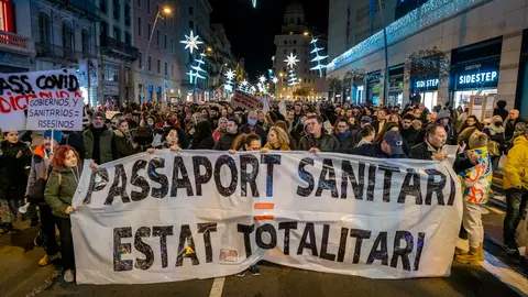 11 December 2021, Spain, Barcelona: Protesters hold a banner during a protest against the vaccination passport and the COVID-19 vaccine. Photo: Paco Freire/SOPA Images via ZUMA Press Wire/dpa.