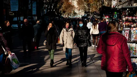 17 December 2021, Spain, Barcelona: People walk along La Rambla in Barcelona. The new Omicron variant of the coronavirus is spreading rapidly in Spain, one of Europe's most popular tourist destinations. Photo: Jordi Boixareu/ZUMA Press Wire/dpa.
