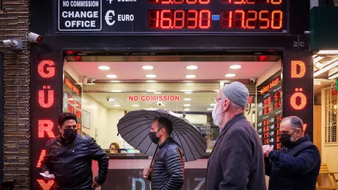 17 December 2021, Turkey, Istanbul: People walk in front of a currency exchange shop in Istanbul. The Turkish central bank cut its benchmark interest rate to 14 per cent on Thursday, the fourth consecutive cut since September, leading the lira to fall to historic lows. Photo: Serkan Senturk/ZUMA Press Wire/dpa.