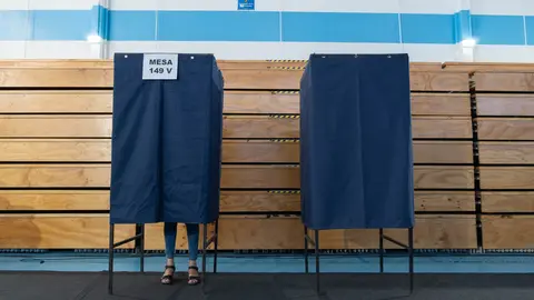 19 December 2021, Chile, Santiago: A voter stands behind a polling booth at a polling station in Santiago during the second round of the presidential election. Chileans have to choose their next president between the right-wing politician Jose Antonio Kast and the former student leader Gabriel Boric. Photo: Matias Basualdo/ZUMA Press Wire/dpa.