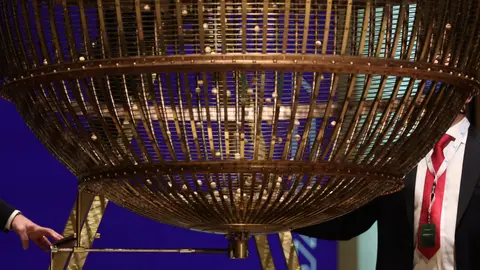 22 December 2021, Spain, Madrid: Preparing the lottery drum and the wooden balls with the ticket numbers shortly before the drawing of the 2021 Christmas lottery in the Teatro Real opera house. Photo: Eduardo Parra/EUROPA PRESS/dpa.