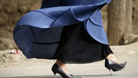 FILED - 30 September 2008, Afghanistan, Taleqan: A women wearing high heels and a burka walks along a street in Taloquan. Taliban religious police in Afghanistan have directed all drivers to refrain from playing music in their cars and not to pick up female passengers who do not follow the Islamic dress code. Photo: Maurizio Gambarini/dpa.