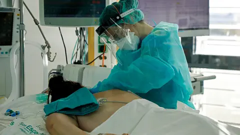 27 December 2021, Spain, Palma: A nurse cares for a patient in the intensive care unit of the main hospital Son Espases for coronavirus patients. Photo: Clara Margais/dpa.