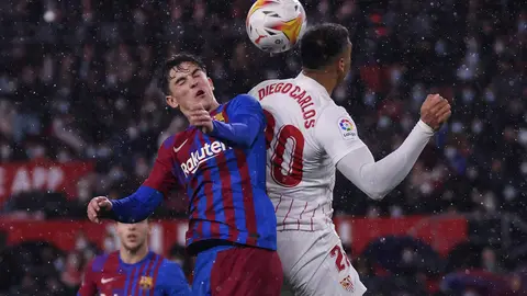 21 December 2021, Spain, Sevilla: Barcelona's Gavi (L) and Sevilla's Diego Carlos battle for the ball during the Spanish La Liga soccer match between Sevilla and Barcelona at Ramon Sanchez-Pizjuan Stadium. Photo: Jose Luis Contreras/DAX via ZUMA Press Wire/dpa.