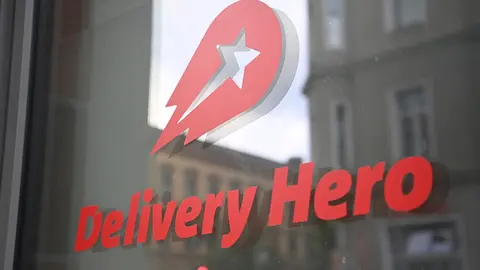 FILED - 19 August 2020, Berlin: The logo of the food delivery service Delivery Hero is seen on a glass pane at the headquarters. Delivery Hero said it was making a U-turn and suspending its food delivery service in its home market Germany, just months after returning to the country, and selling its business in Japan. Photo: Britta Pedersen/dpa-Zentralbild/dpa.