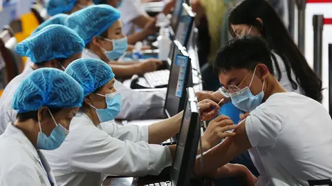 FILED - Health workers vaccinate 3,318 senior high school graduates as the Qianjiang District of Chongqing City organizes a coronavirus vaccination campaign to establish an immune barrier as soon as possible in this file shot from June 11, 2021. Photo: Yang Min/SIPA Asia via ZUMA Wire/dpa.