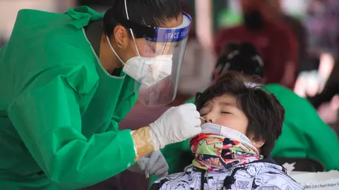 FILED - A health worker takes a swab for a coronavirus test from a child at a test centre in Toluca. Photo: -/El Universal via ZUMA Press Wire/dpa.