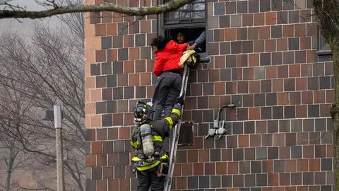 09 January 2022, US, New York: A firefighter hoists a ladder to rescue people through their windows after a fire broke out inside a third-floor duplex apartment in a Bronx apartment building, left at Least 19 Dead, Including 9 Children. Photo: Theodore Parisienne/New York Daily News/dpa.