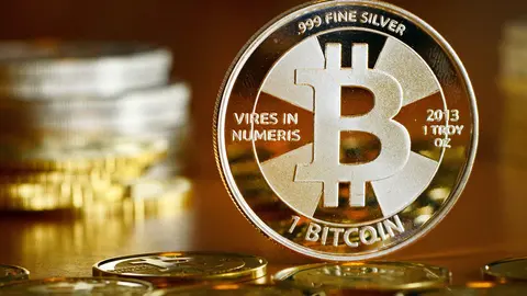 FILED - 28 November 2013, Berlin: A general view of a coin bearing the logo of the Bitcoin cryptocurrency at a coin store. The value of Bitcoin fell below 40,000 dollars on Monday for the first time since September. Photo: Jens Kalaene/zb/dpa.