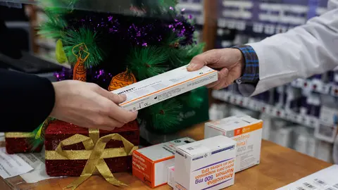 21 December 2021, Spain, Madrid: A person picks up a free antigen test at a pharmacy in Madrid. The Government of the Community of Madrid has made antigen tests available for free for its citizens before the Christmas gatherings. Photo: Alejandro Martínez Vélez/EUROPA PRESS/dpa.