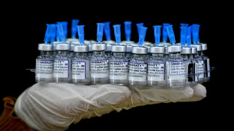13 January 2022, Malaysia, Kuala Terengganu: A medic carries a tray with vials of anti-coronavirus vaccine at a vaccination centre. Photo: Mohd Syafiq Ambak (str)/BERNAMA/dpa.