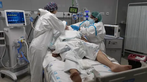 13 January 2022, Spain, Madrid: Health care workers treat a patient admitted to the intensive care unit of Enfermera Isabel Zendal Hospital. The 14-day cumulative incidence rate in the Community of Madrid increased by 87.35 to 2,528.84 cases per 100,000 inhabitants, according to the Ministry of Health. Photo: Eduardo Parra/EUROPA PRESS/dpa.