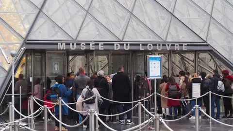 FILED - Visitors stand in front of the Louvre Pyramid inside the museum courtyard. Photo: Christian Böhmer/dpa.