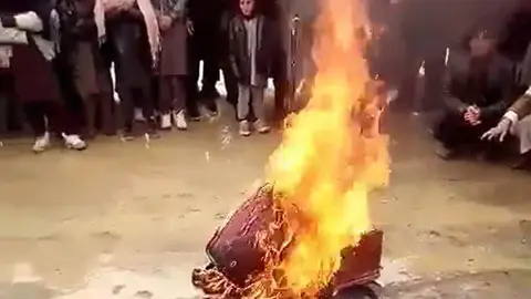 Bonfire in which musical instruments burn. Image: Twitter video screenshot.