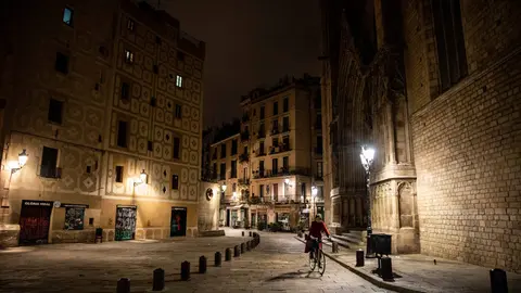24 December 2021, Spain, Barcelona: A woman rides her bike in central Barcelona street during curfew time that was imposed as part of coronavirus measures. Photo: Kike Rincón/EUROPA PRESS/dpa.