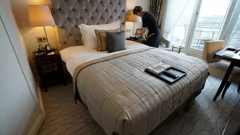 FILED - 30 November 2021, Hamburg: An employee of the luxury hotel "Vier Jahreszeiten" prepares a room for the next hotel guests. The restrictions imposed on public life to combat the Corona pandemic have hit the tourism sector in Germany hard for the second year in a row. Photo: Marcus Brandt/dpa.