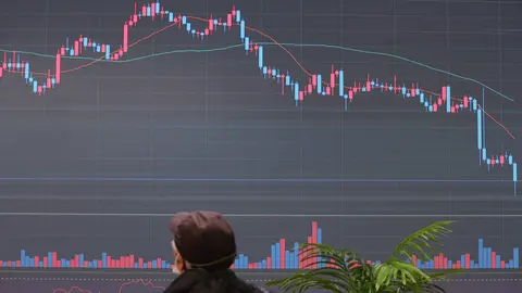 07 January 2022, South Korea, Seoul: A man looks at an electronic signboard of a cryptocurrency exchange in Seoul that shows the price of bitcoin having nose-dived during a trading session, in the wake of a massive disturbance in Kazakhstan, a major bitcoin mining hub. Photo: -/YNA/dpa.